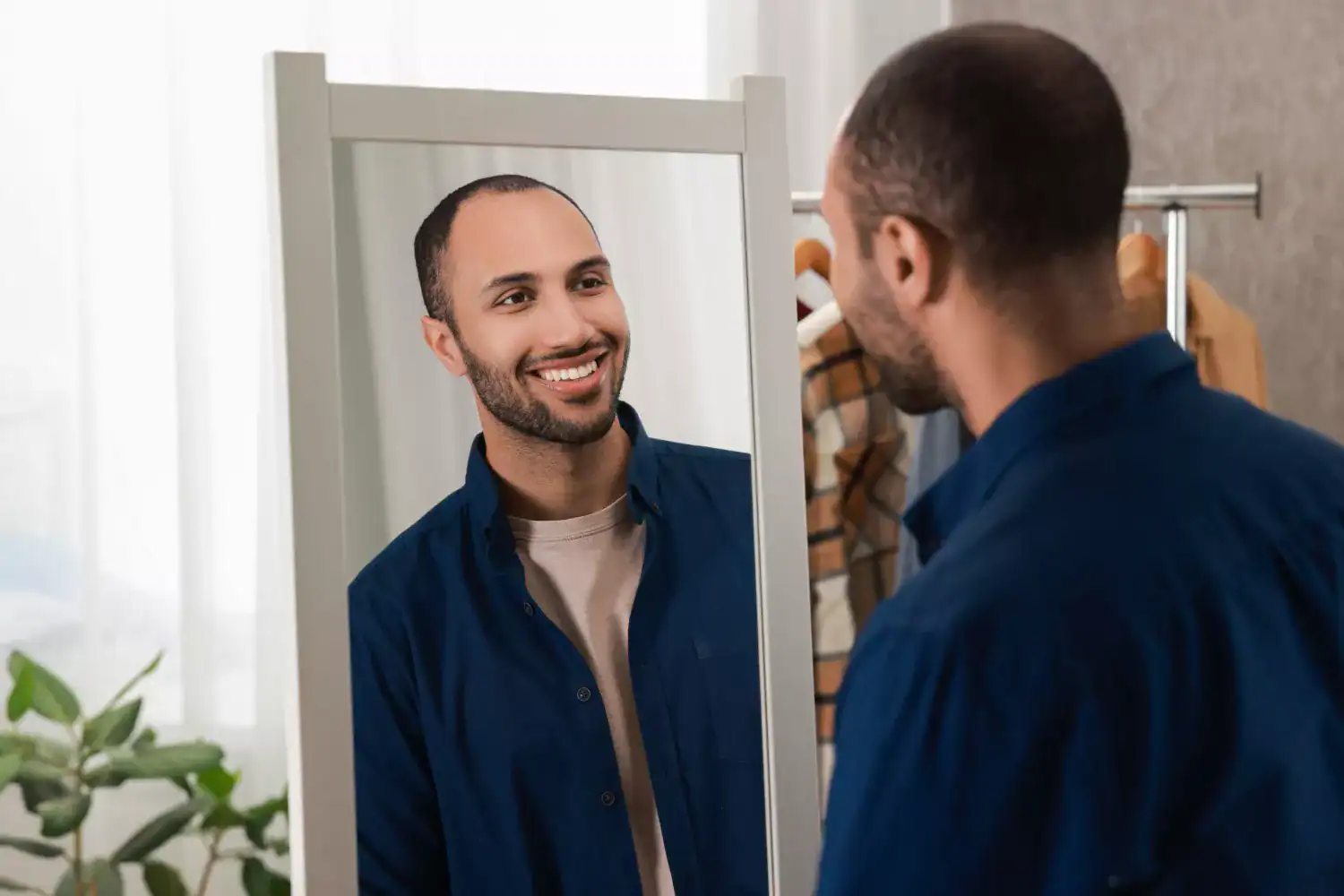 A person standing in front of a mirror, looking at their own reflection, symbolizing themes of self‑focus and narcissism