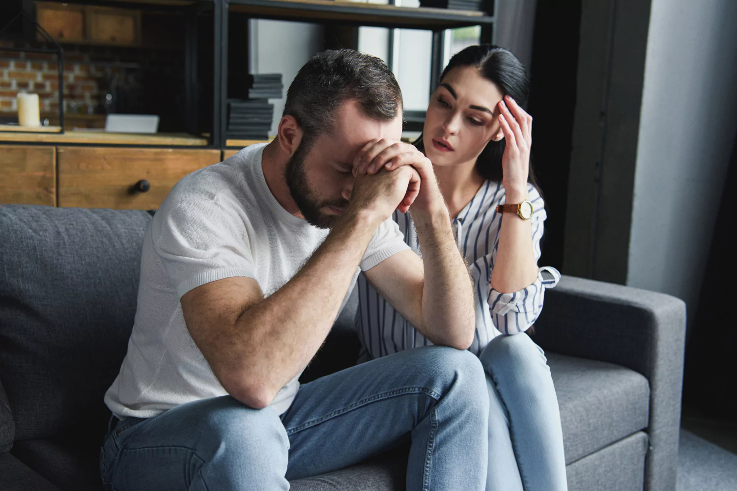 Discouraged man sits with head in hands while woman beside him offers support, reflecting emotional strain and the need to escape ministry burnout.