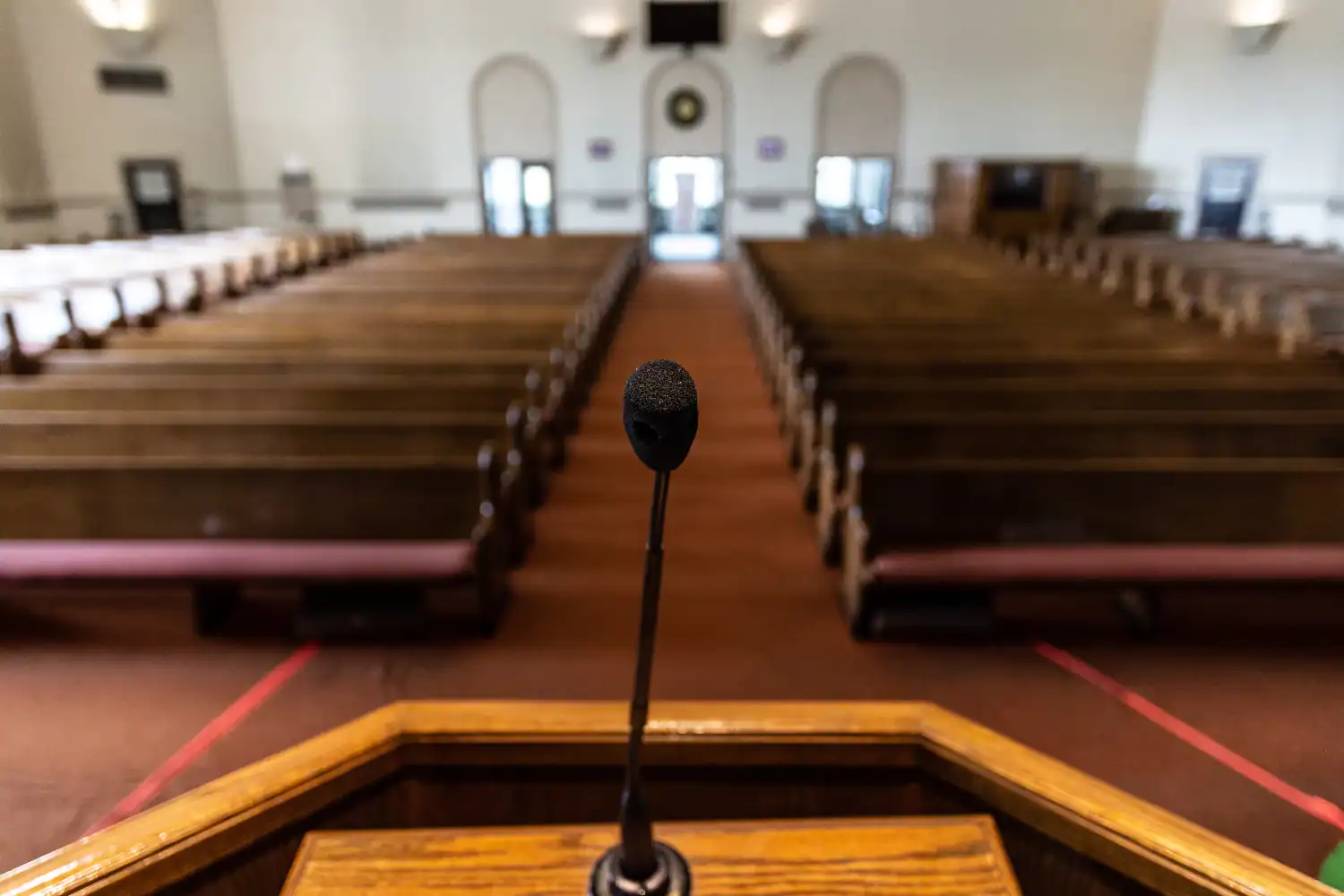 View from an empty church pulpit with microphone facing vacant pews, illustrating the concept of why sermons fail.
