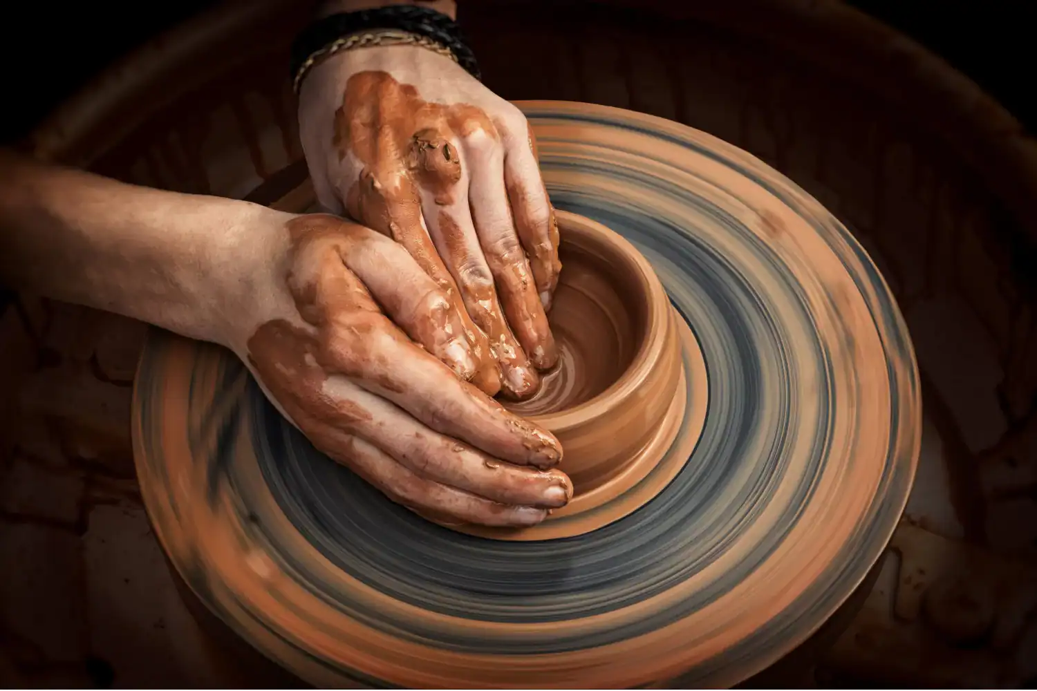Hands shaping clay on a pottery wheel, symbolizing God as Creator and the Christian doctrine of humanity.