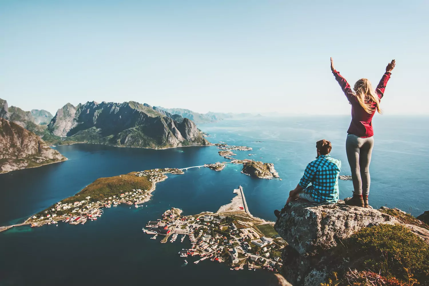 A man and a woman sit on some rocks far up above a bay. The man sits while the womans stands with her arm outstretched. A couple in ministry could have some reservations about such a trip. You may think that the cost doesn’t warrant such an indulgence. Consider the following points, which show the benefits of a planned family adventure.