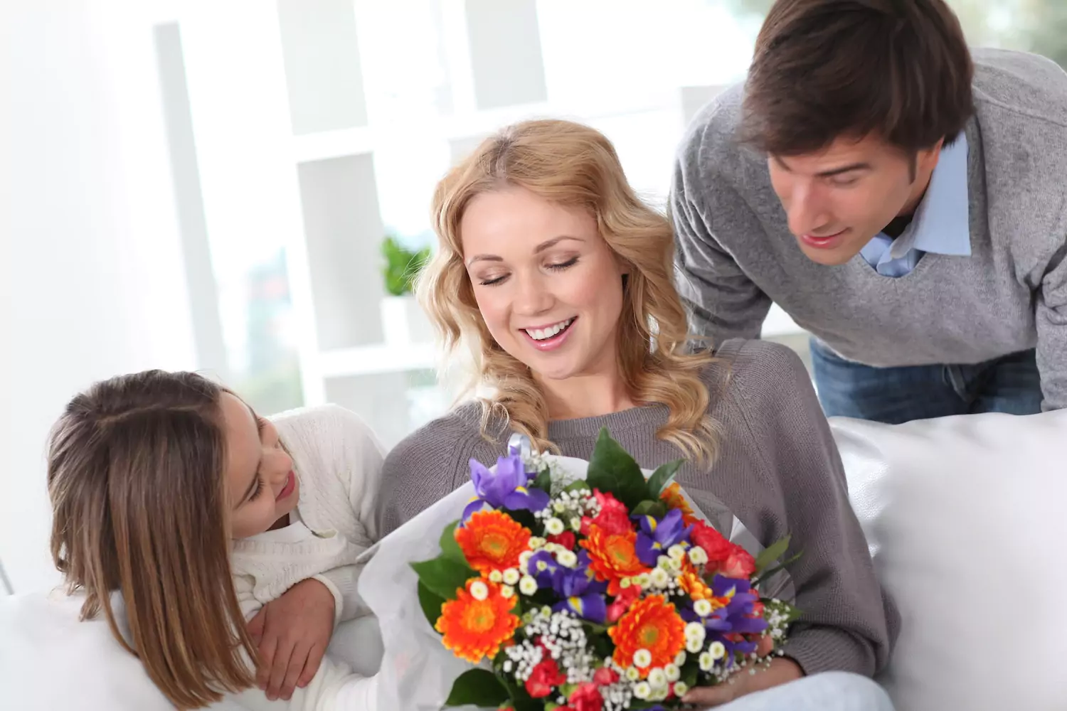 Dad and daughter giving flowers to mom