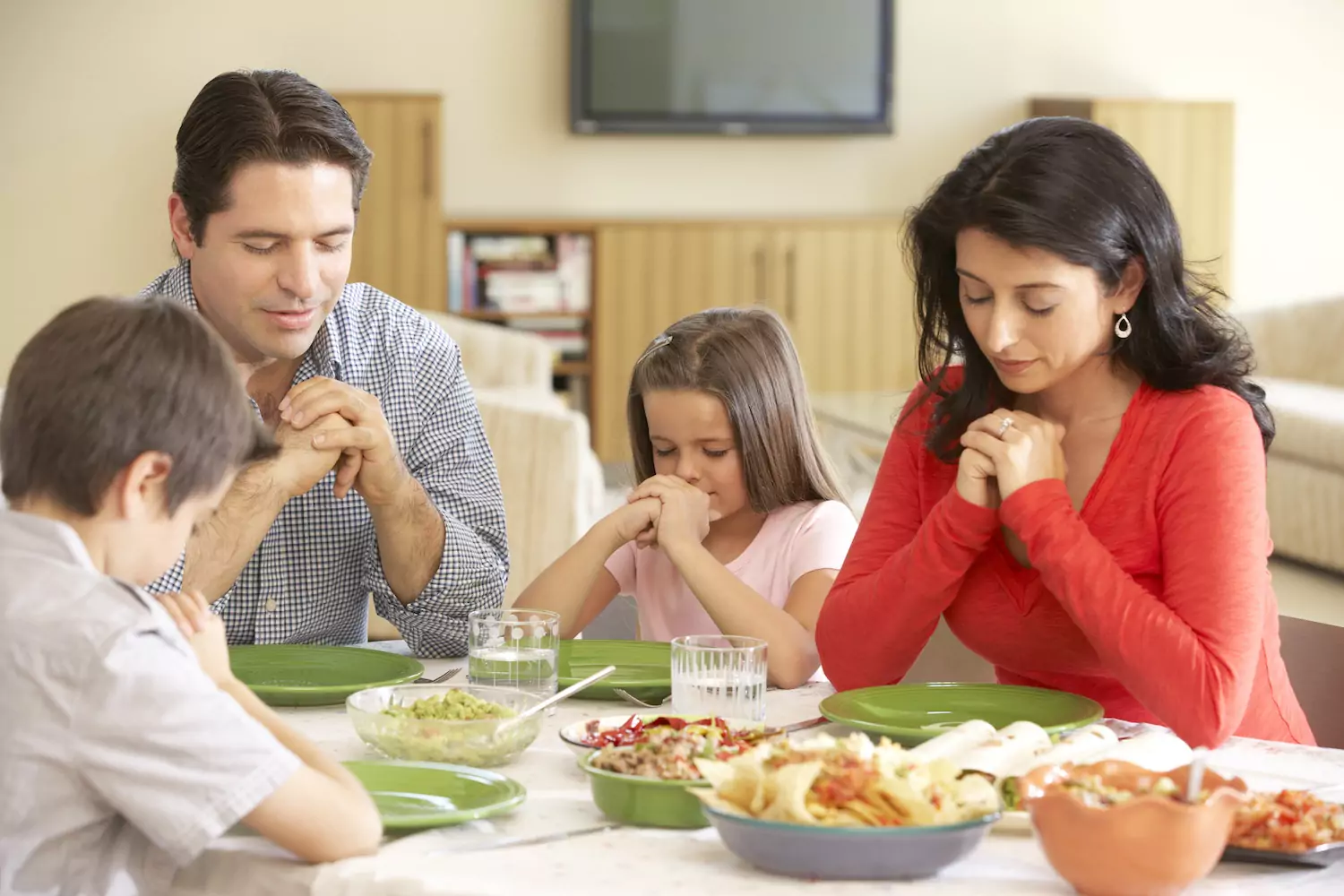 Family offering a Mother's Day prayer before a meal