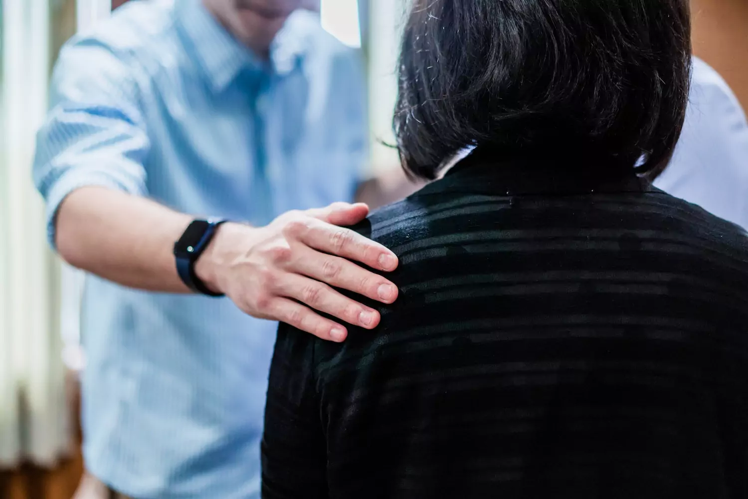 A man comforting another person with Conviction, Context, and Compassion.