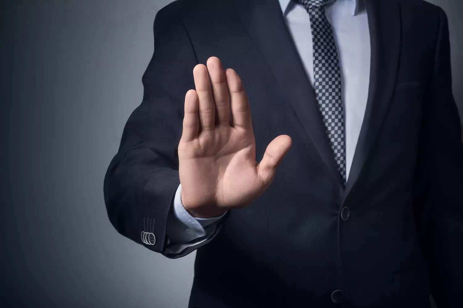 man in suit signing stop with his hand