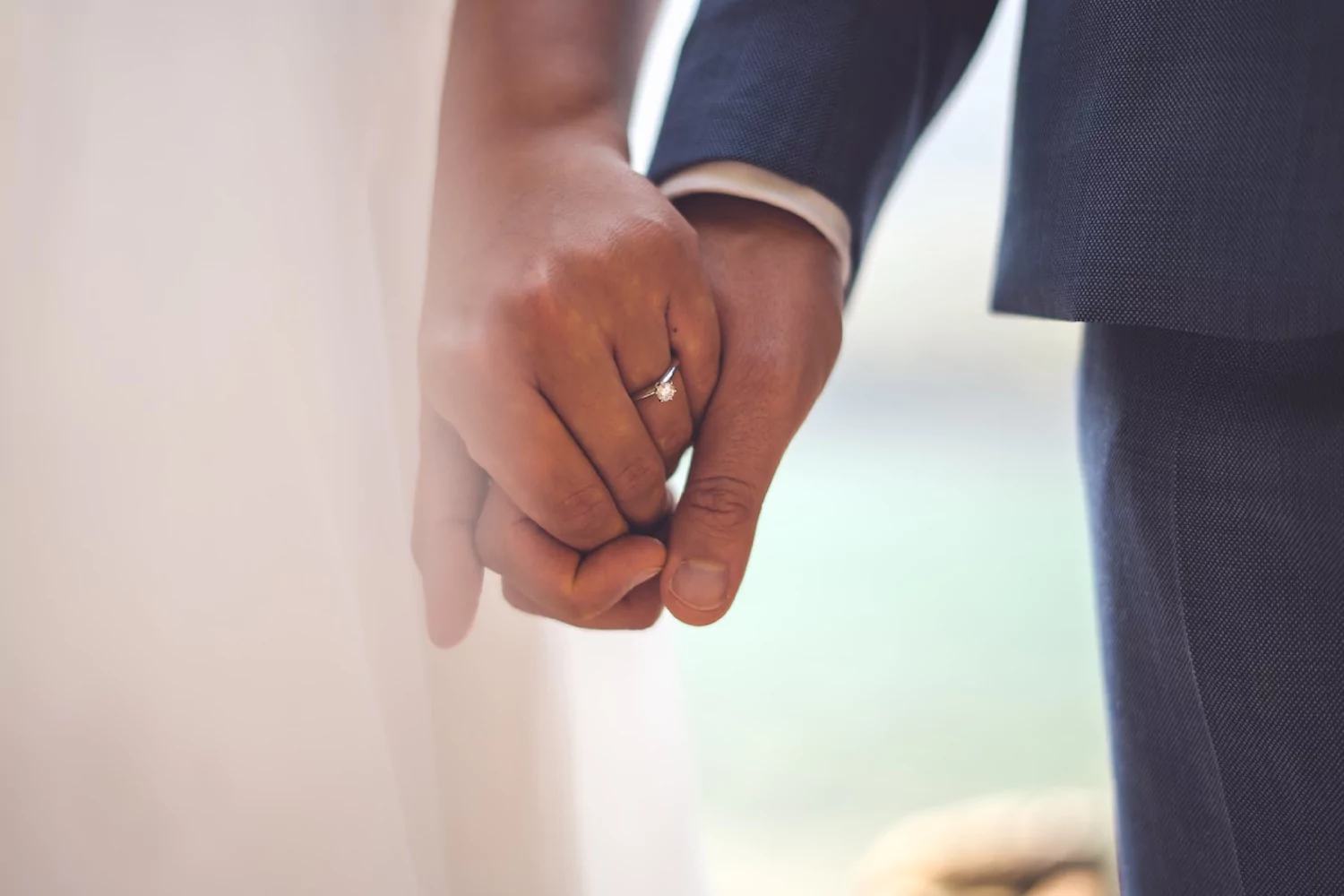 a close-up of a new husband and wife holding hands on their wedding day