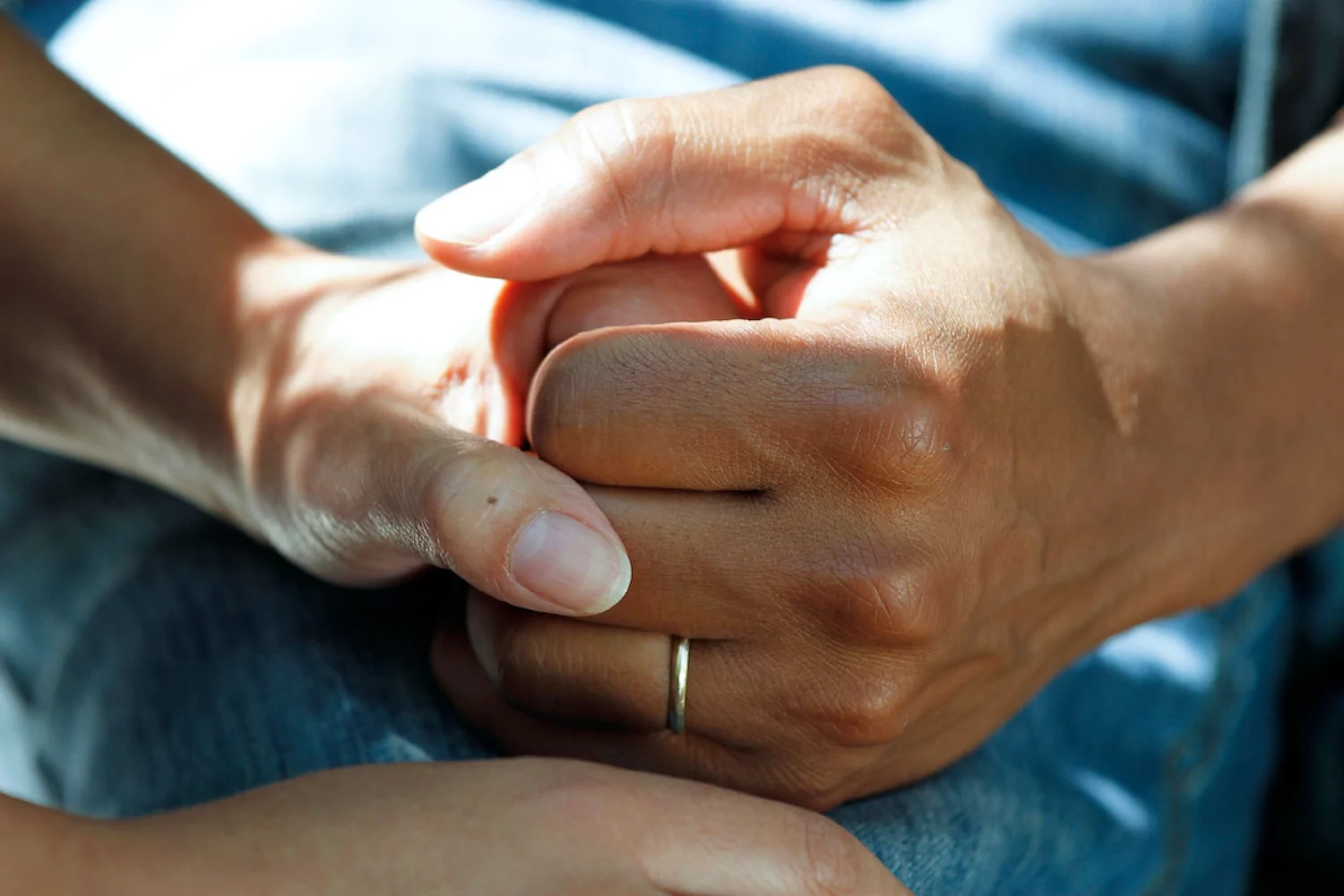close-up of a wife holding her husband's hand supportively