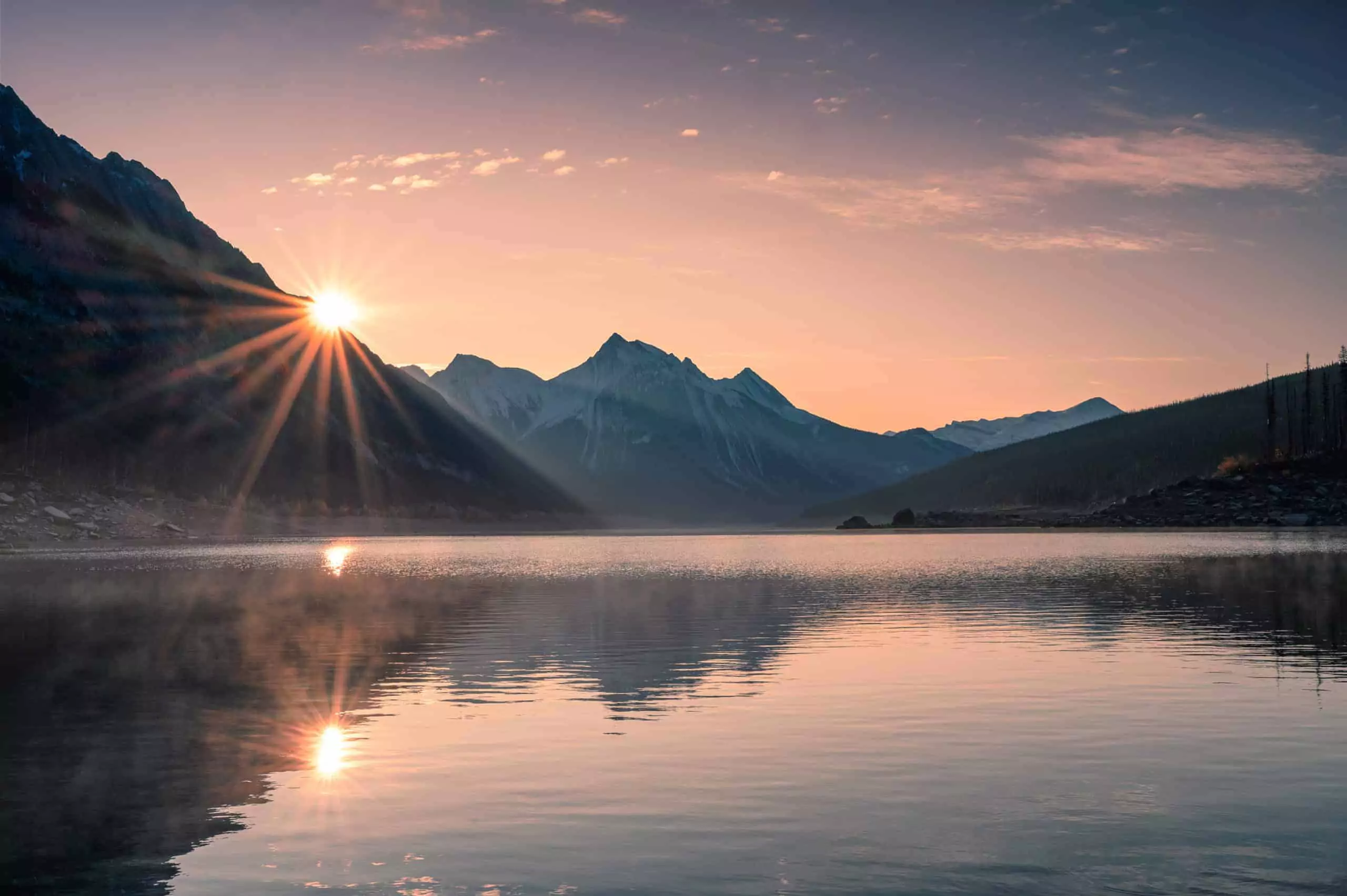 Sunset behind mountains around a lake