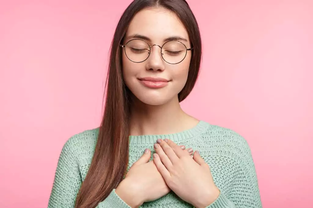 a woman placing her hands over her heart