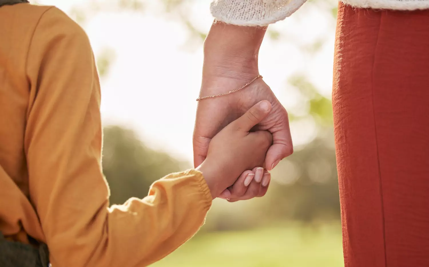 a pastor's wife holds her sad daughter's hand outside