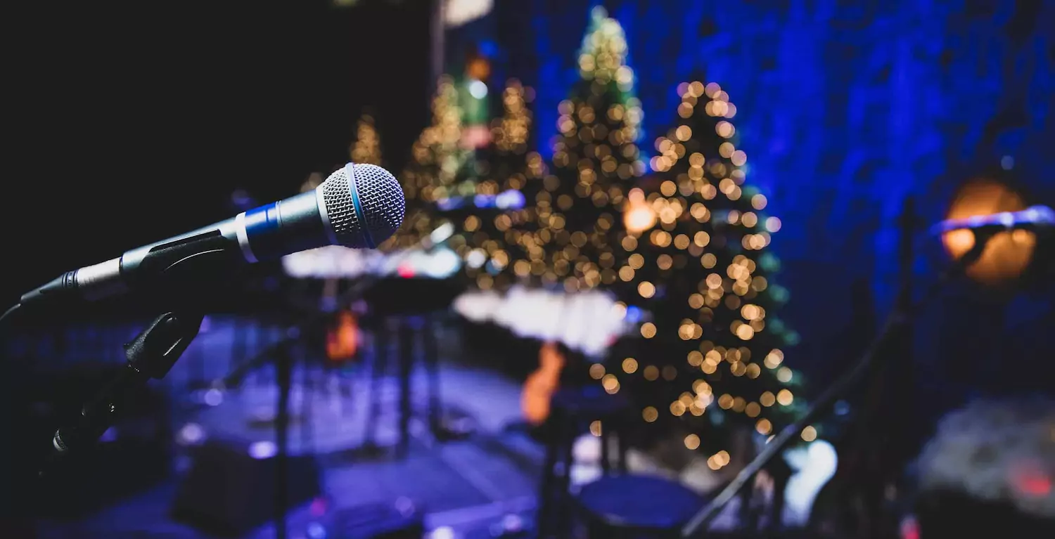 Microphone on a church stage decorated with Christmas trees.