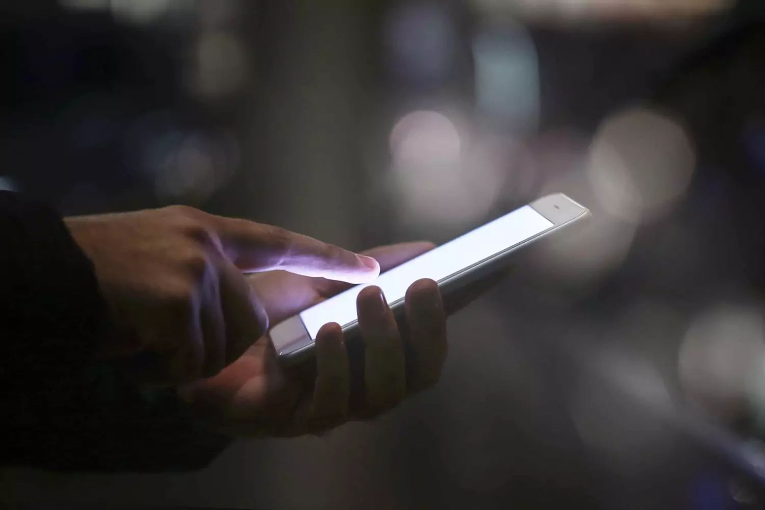 A man scrolls on his phone in the dark, struggling with pornography.