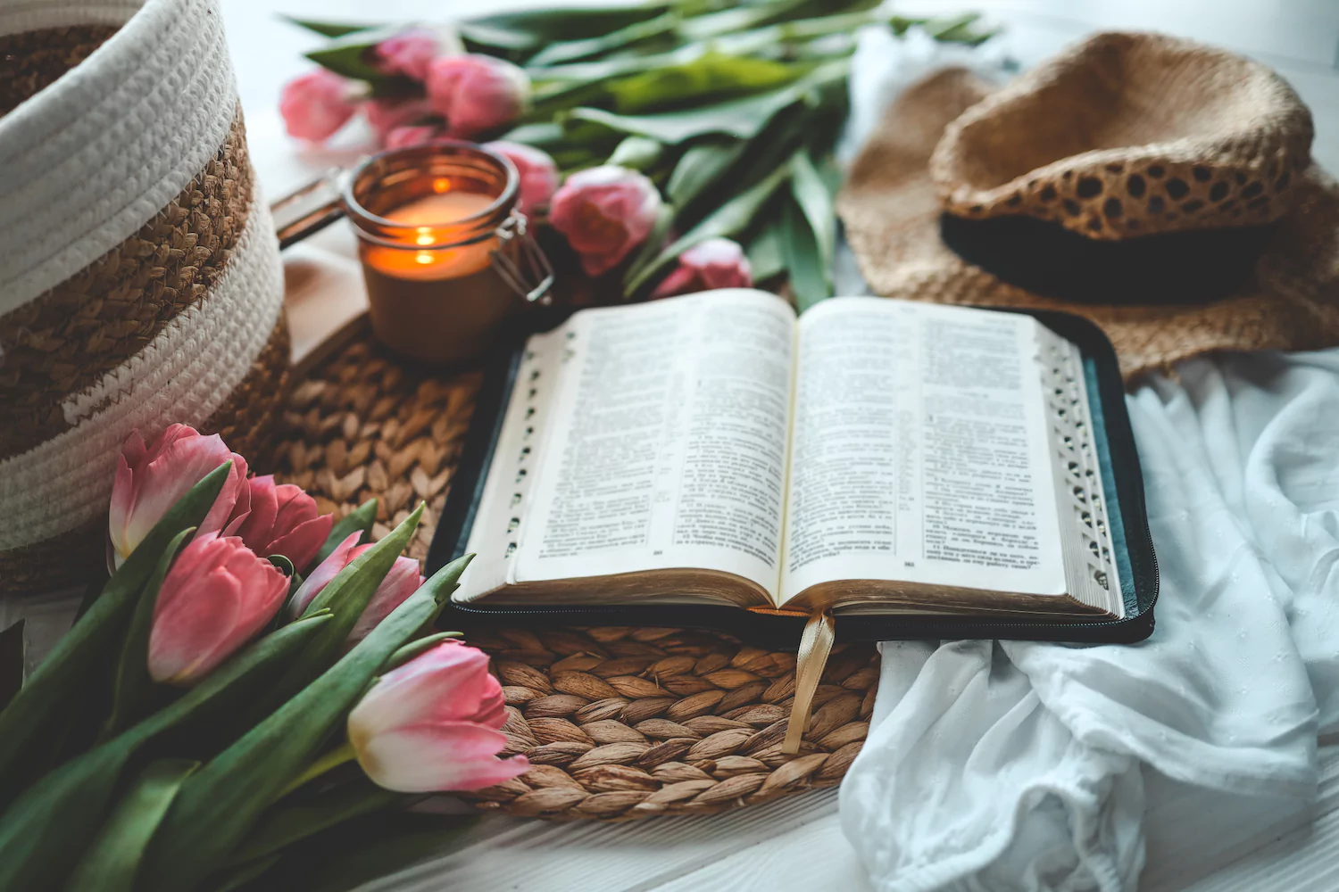 A Bible sits open on a white table with festive tulips as easter decor.