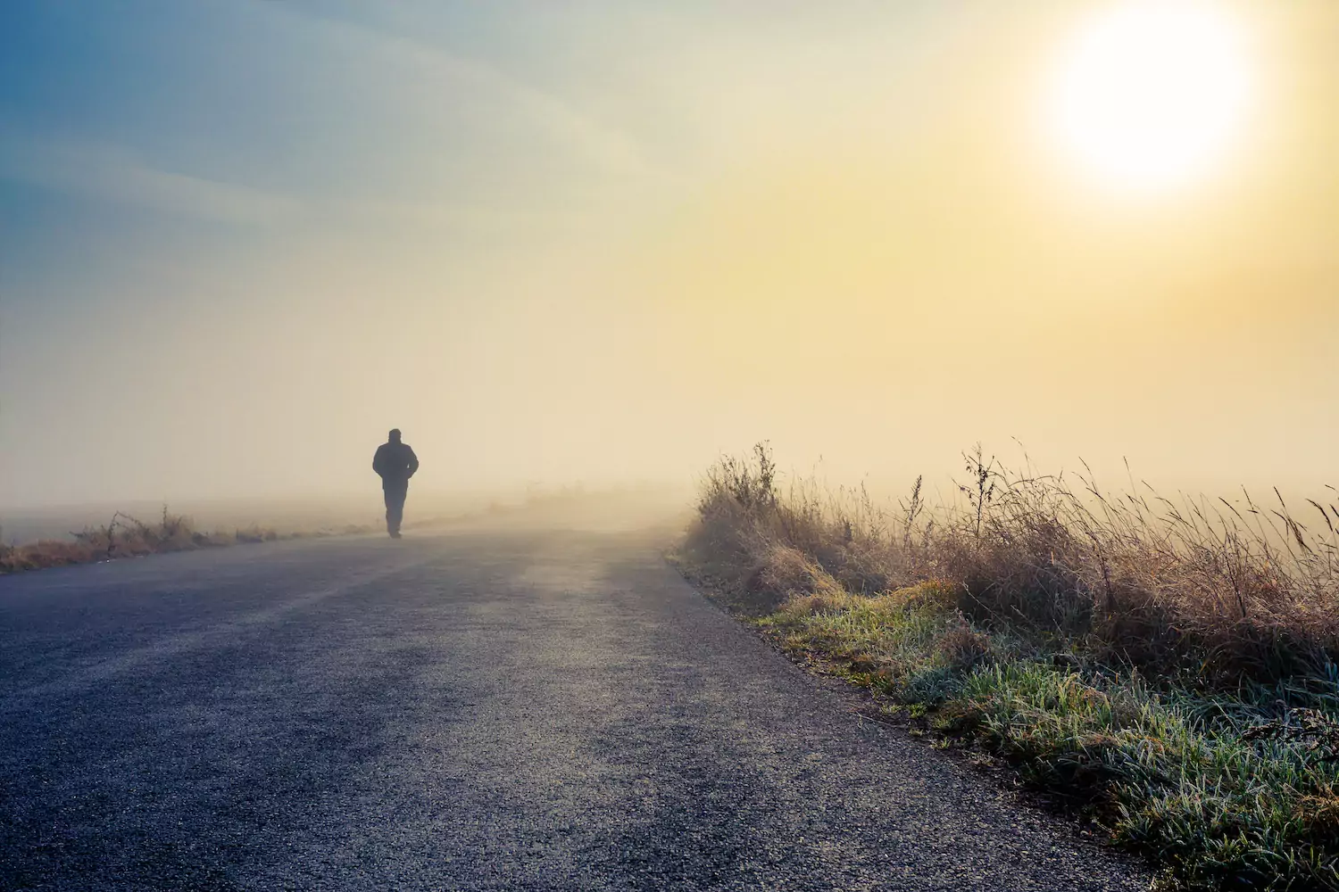 A pastor anxious about inadequacy walks down a rural road in morning fog.