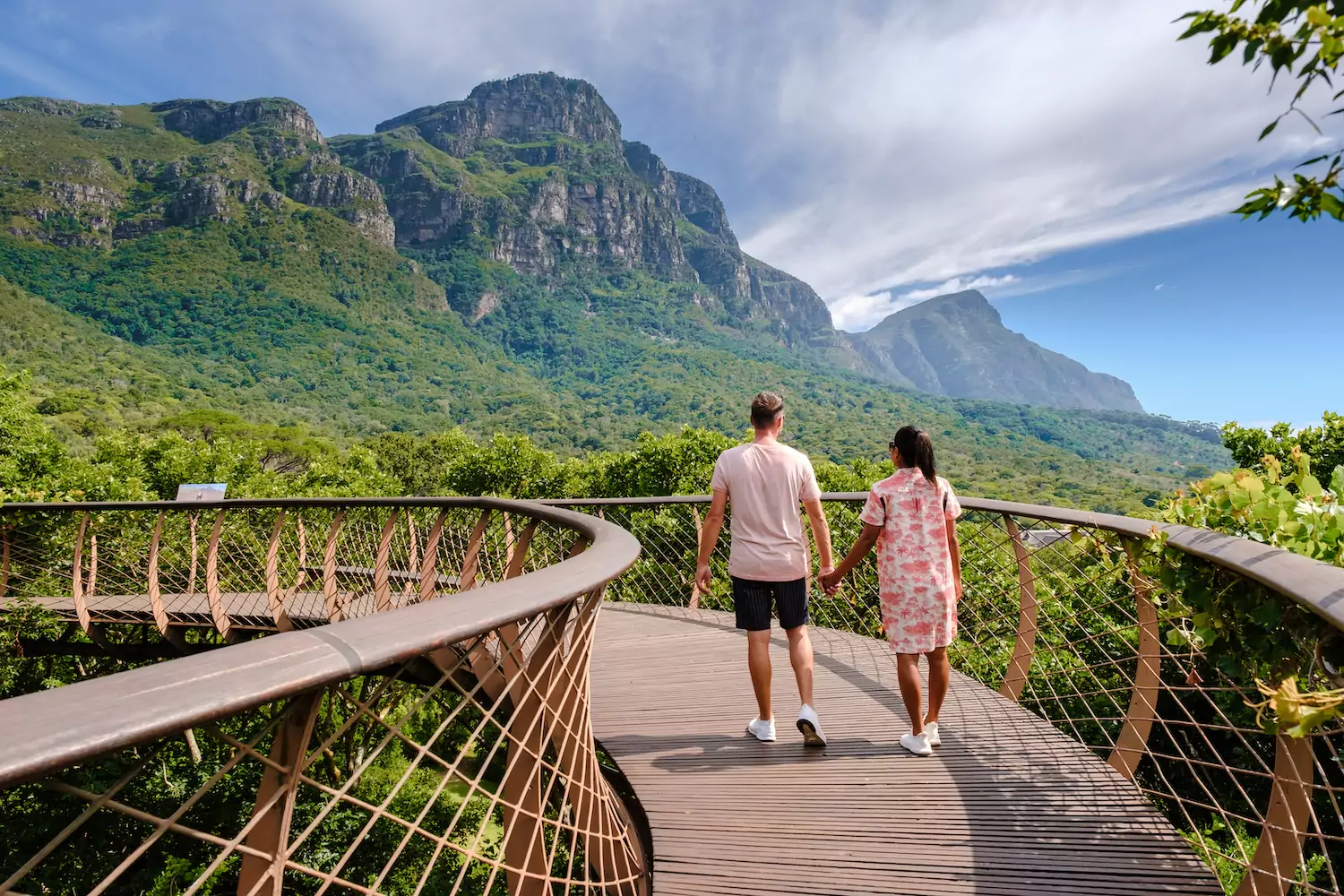 A missionary couple walks across a rural bridge.