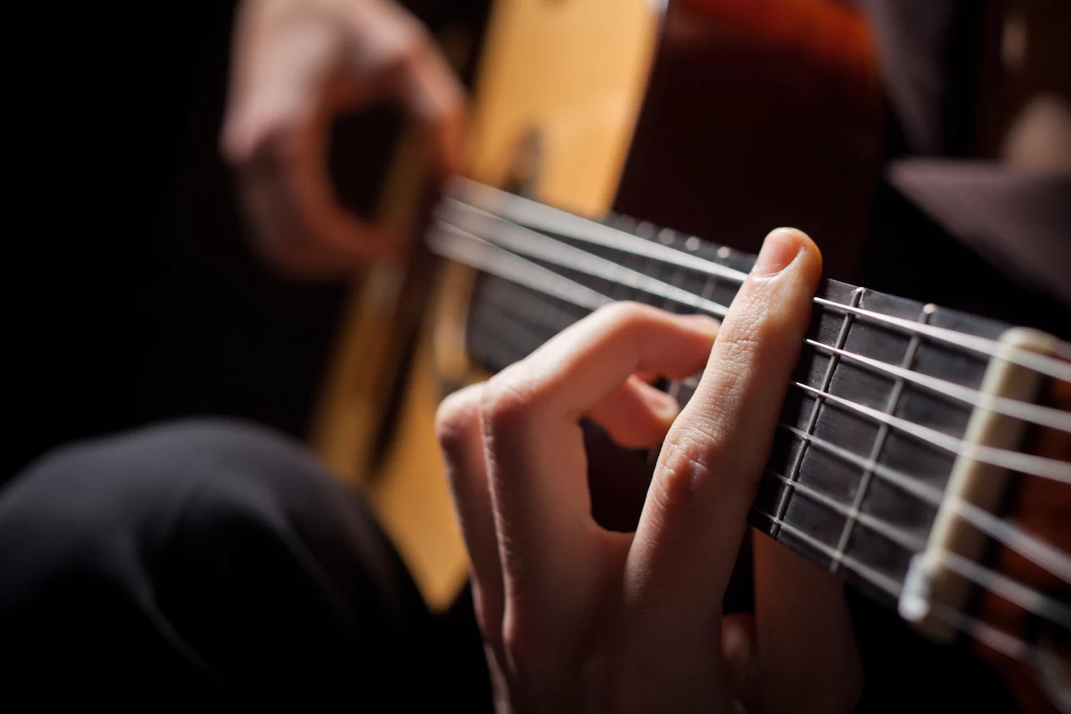 A close-up of a worship pastor playing a guitar.