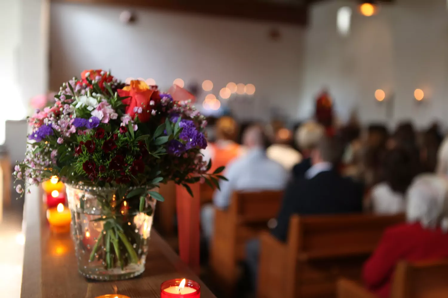 Flowers and candles in the sanctuary of a crowded, growing church.