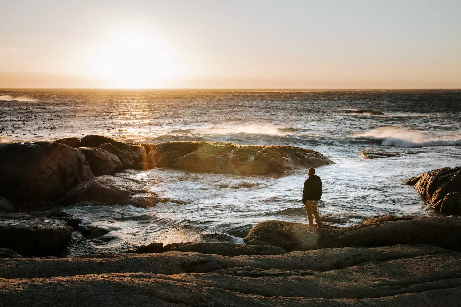 Adult male church member looking off into the distant ocean at sunset, trusting God despite living with pain.