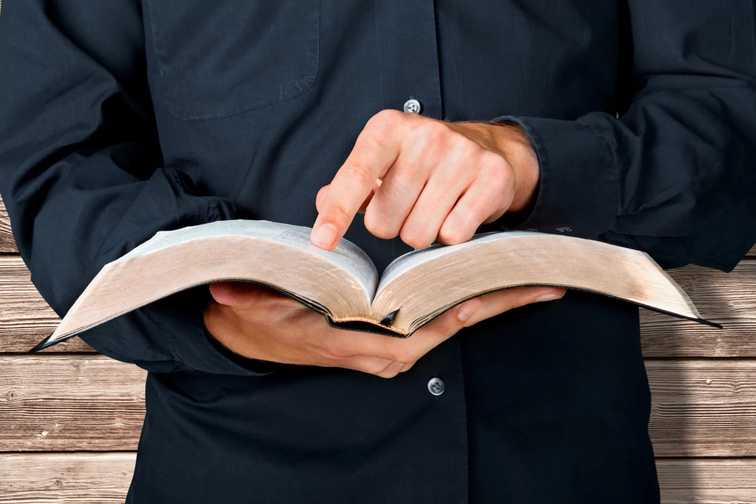 man preaching a book of the Bible
