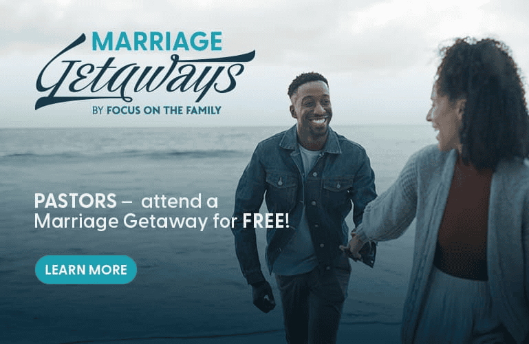 A smiling couple walks hand in hand along an ocean shoreline. Text overlay reads "Marriage Getaways by Focus on the Family - Pastors, attend a Marriage Getaway for FREE!" with a "Learn More" button.
